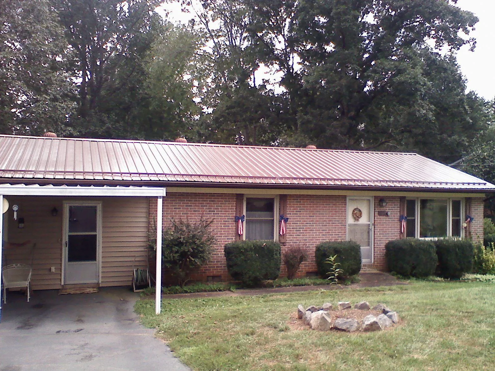 Bronze metal roof and carport on a brick ranch home — Roof Repair work by our crew in Warsaw